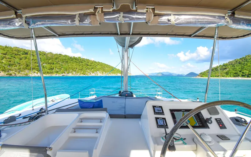 Whiskey Business Yacht Photos Pics 2015 Lagoon 450F catamaran cockpit with scenic ocean view and lush green islands.
