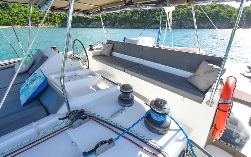 Whiskey Business Yacht Photos Pics 2015 Lagoon 450F yacht deck with seating, ocean view, and lush coastline.