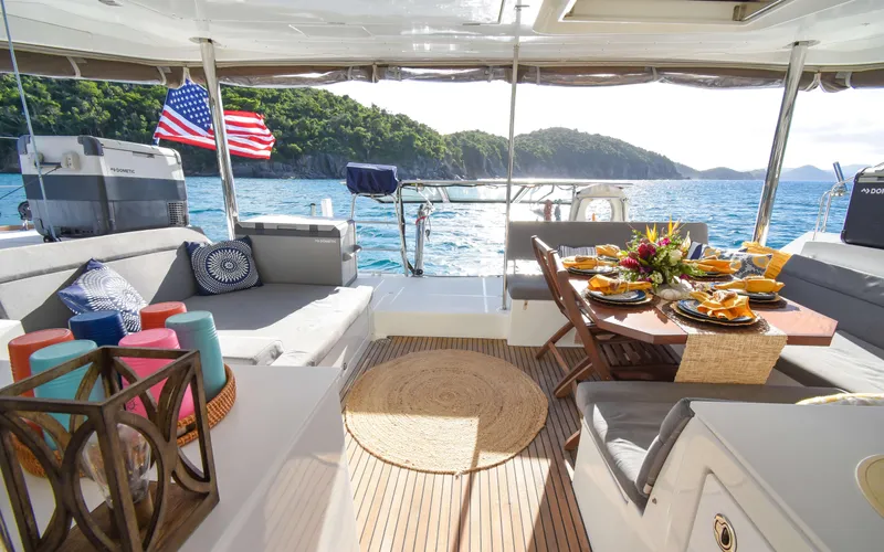 Whiskey Business Yacht Photos Pics Luxurious 2015 Lagoon 450F yacht interior with dining setup, ocean view, and American flag.