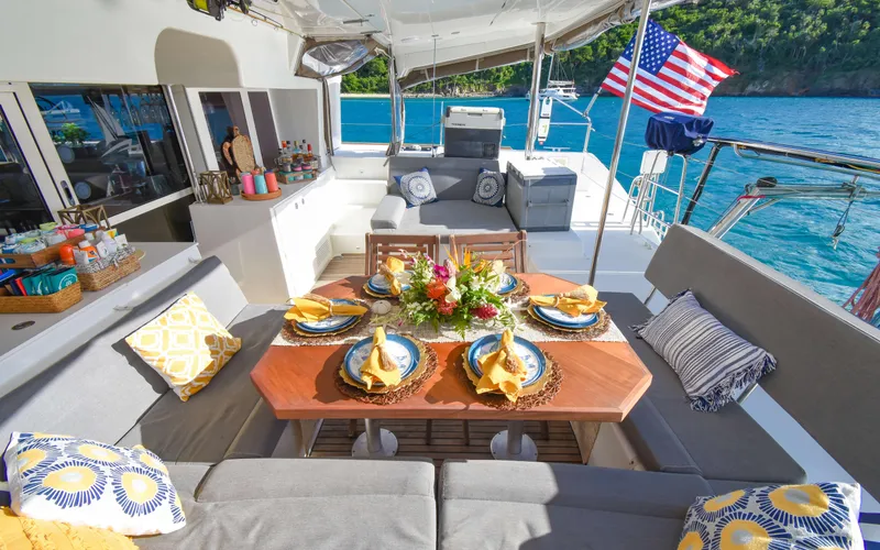 Whiskey Business Yacht Photos Pics Luxurious 2015 Lagoon 450F yacht with elegant outdoor dining setup and scenic ocean view.