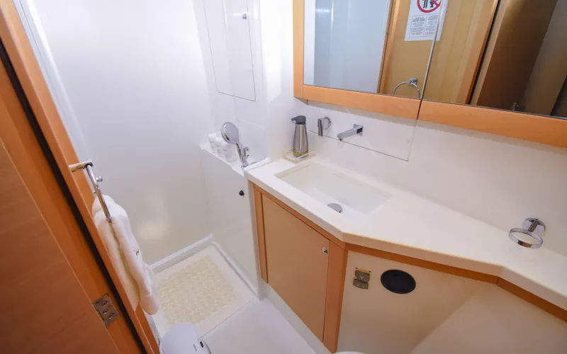 Whiskey Business Yacht Photos Pics 2015 Lagoon 450F yacht bathroom with modern sink, mirror, and shower area.