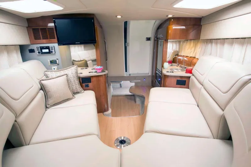 Opty Mystic Yacht Photos Pics 2018 Formula 310 Sun Sport cabin interior with beige leather seating, TV, and kitchenette.