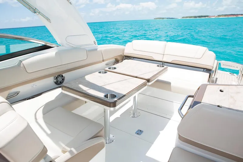 Opty Mystic Yacht Photos Pics 2018 Formula 310 Sun Sport boat interior with seating and tables on turquoise water.