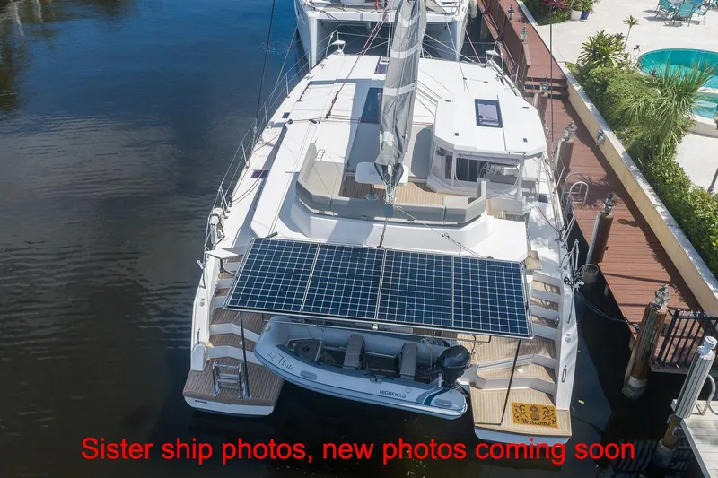 Just Lion Around Yacht Photos Pics Aerial view of 2020 Leopard 45 catamaran docked, featuring solar panels and a dinghy.