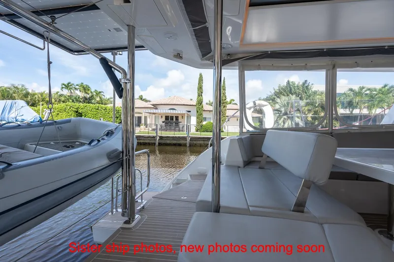 Just Lion Around Yacht Photos Pics Leopard 45 catamaran interior with seating area and docked inflatable boat, 2020 model.