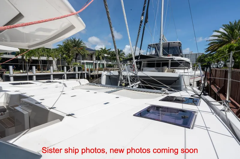 Just Lion Around Yacht Photos Pics 2020 Leopard 45 catamaran docked, awaiting new photos, with palm trees and blue sky backdrop.