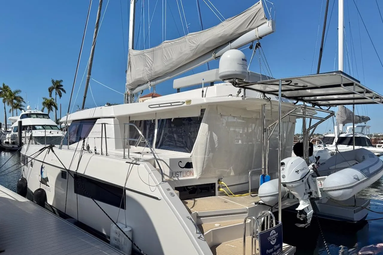 2020 Leopard 45 catamaran docked at marina with inflatable boat and palm trees.