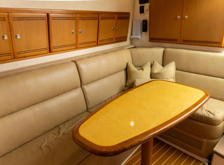 Miss Shell Yacht Photos Pics Interior of 2008 Cabo 38 Express with beige seating and wooden table.