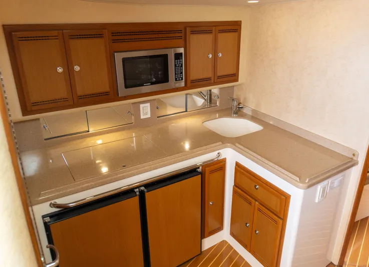 Miss Shell Yacht Photos Pics 2008 Cabo 38 Express boat kitchen with microwave, sink, and wooden cabinets.