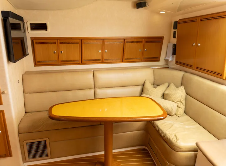 Miss Shell Yacht Photos Pics Interior of 2008 Cabo 38 Express yacht with beige seating and wooden table.