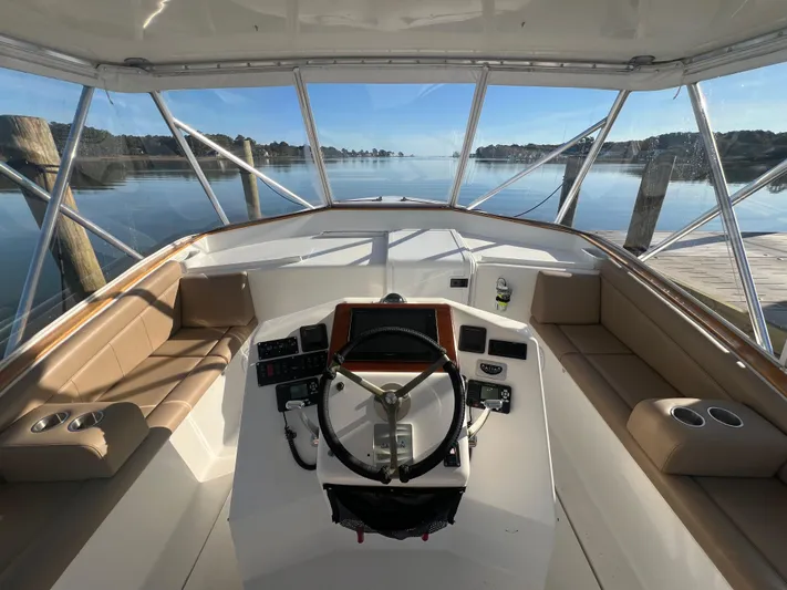 Precedent Yacht Photos Pics 1998 Jersey Cape 36 Express boat interior with steering wheel and seating, docked by calm water.