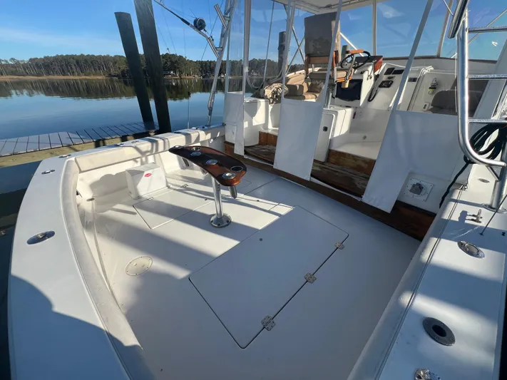Precedent Yacht Photos Pics 1998 Jersey Cape 36 Express boat interior with fishing rod holders, docked by calm water.