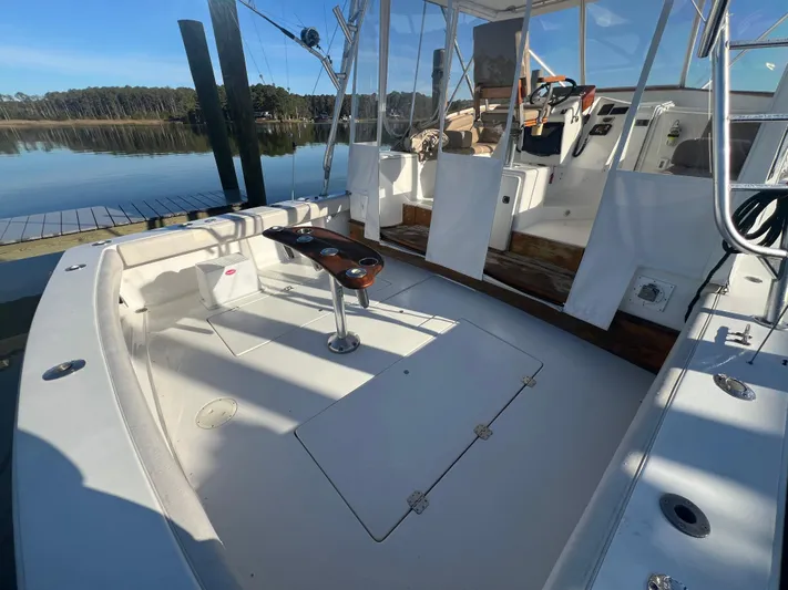 Precedent Yacht Photos Pics 1998 Jersey Cape 36 Express boat interior with fishing rod holders, docked by calm waters.