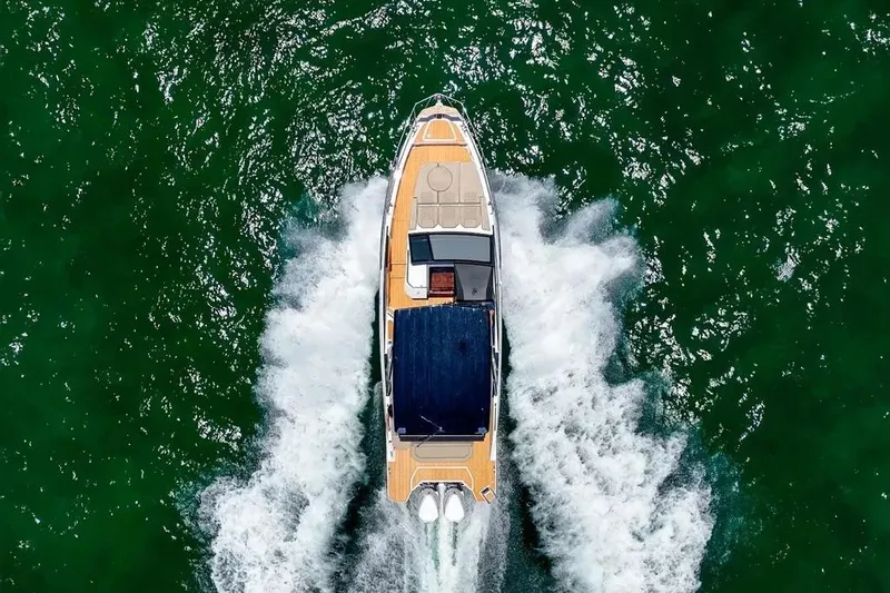  Yacht Photos Pics Aerial view of 2025 Hanover 347 boat cruising on green water.