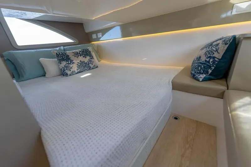  Yacht Photos Pics Modern boat interior with cozy bed, decorative pillows, and ambient lighting in Hanover 347, 2025 model.