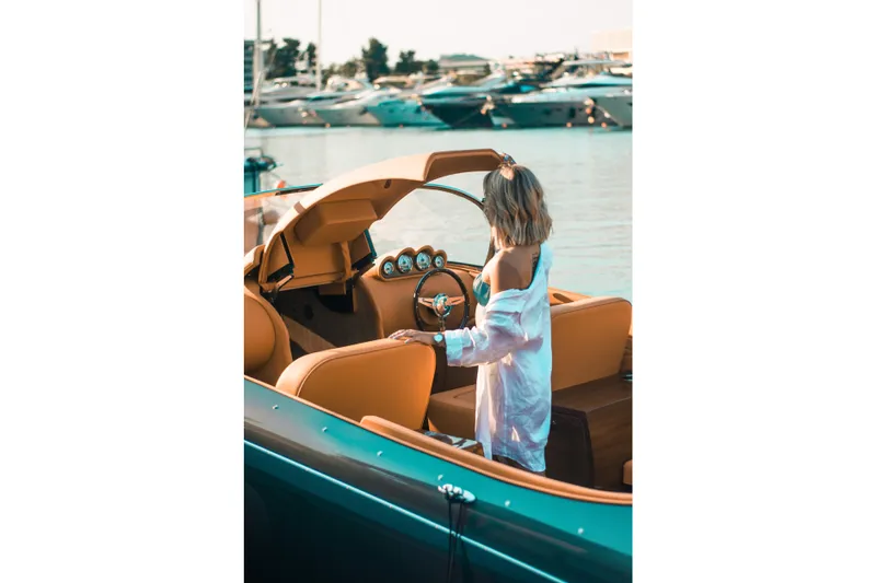  Yacht Photos Pics Woman steering 2025 Seven Seas Yachts Venus Speedster X, docked at marina.