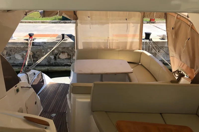  Yacht Photos Pics Interior view of a 2009 Prestige 38S yacht with beige seating and table.