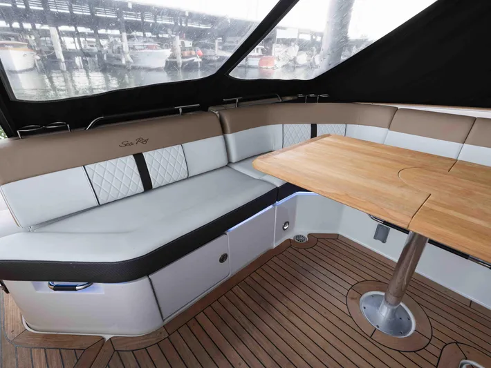  Yacht Photos Pics 2019 Sea Ray SLX 400 interior with cushioned seating and wooden table, docked at marina.