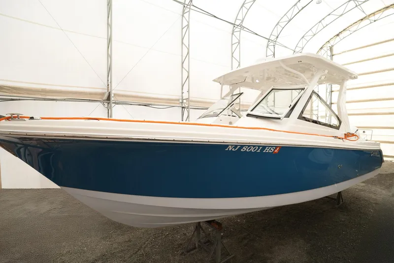  Yacht Photos Pics 2022 Edgewater 262 CX boat in storage, blue hull, white top.