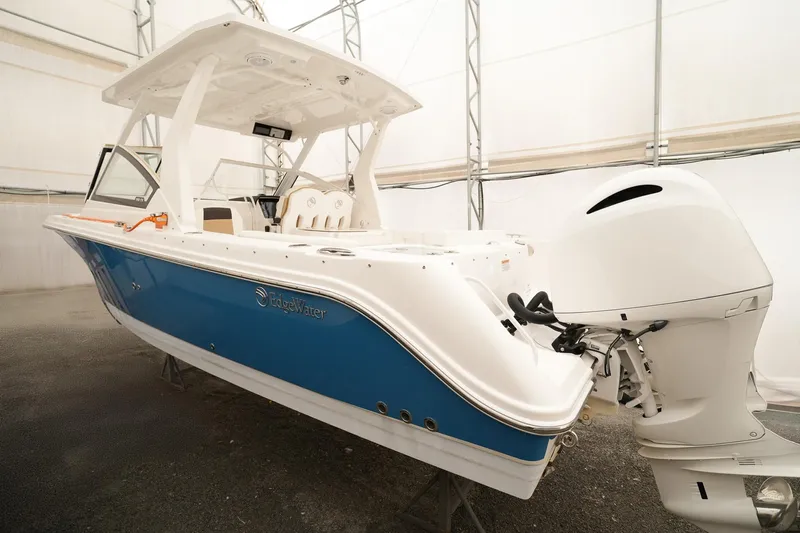  Yacht Photos Pics 2022 Edgewater 262 CX boat with blue hull and white interior in storage.