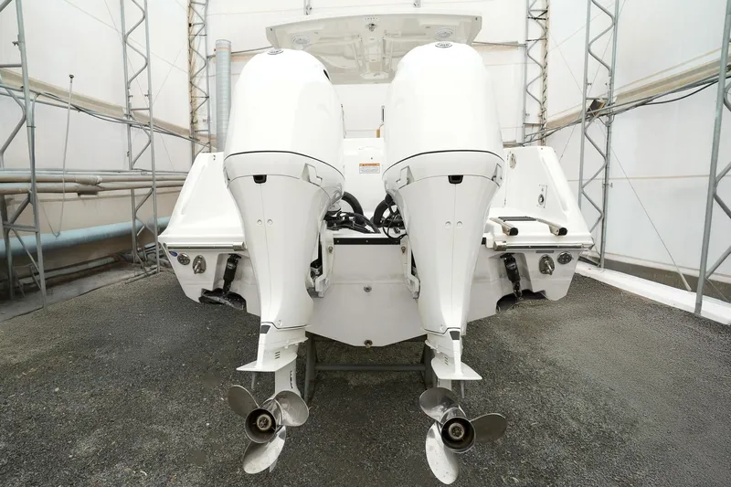  Yacht Photos Pics 2022 Edgewater 262 CX boat with dual outboard engines in a storage facility.