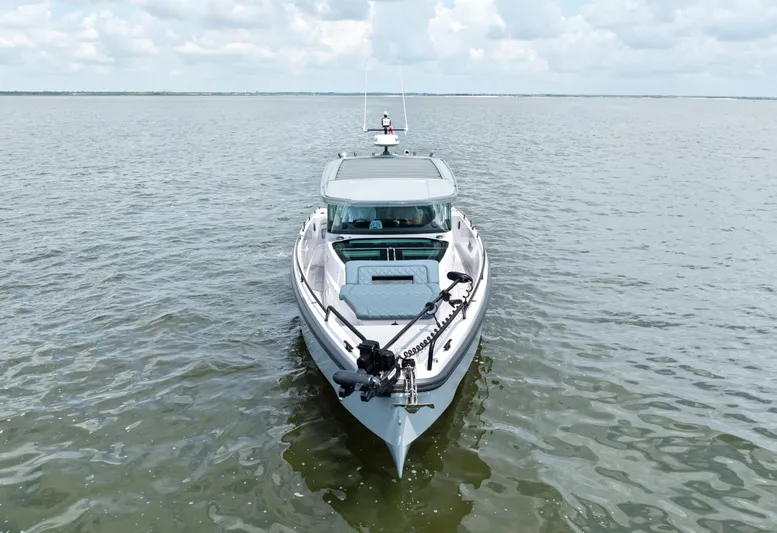  Yacht Photos Pics 2023 Axopar 37XC CROSS CABIN boat on calm water under cloudy sky.