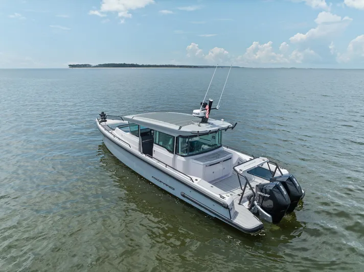  Yacht Photos Pics 2023 Axopar 37XC CROSS CABIN boat on calm water under blue sky.