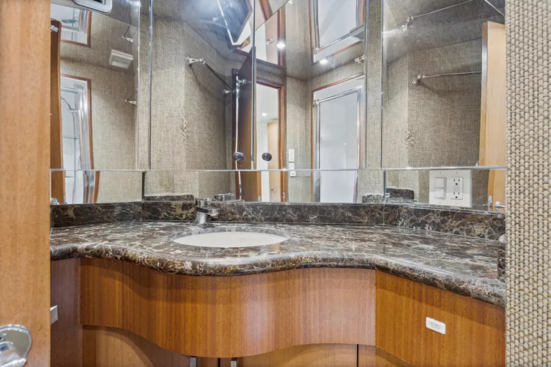 Blacksmith Yacht Photos Pics Luxurious bathroom in 2008 Hatteras 60 Convertible yacht with marble countertop and mirrored walls.