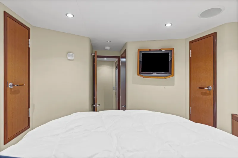 Blacksmith Yacht Photos Pics Luxurious cabin interior of 2008 Hatteras 60 Convertible yacht with TV and wooden doors.