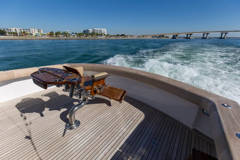 Blacksmith Yacht Photos Pics 2008 Hatteras 60 Convertible yacht deck with fishing chair, cruising near a bridge.