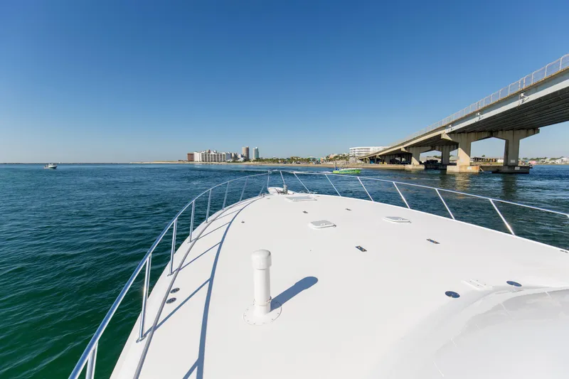 Blacksmith Yacht Photos Pics Bow view of 2008 Hatteras 60 Convertible yacht approaching a bridge on a sunny day.