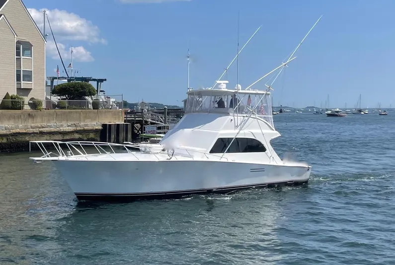 Murphy's Law Yacht Photos Pics White 1997 Post 50 Convertible yacht cruising near a marina on a sunny day.