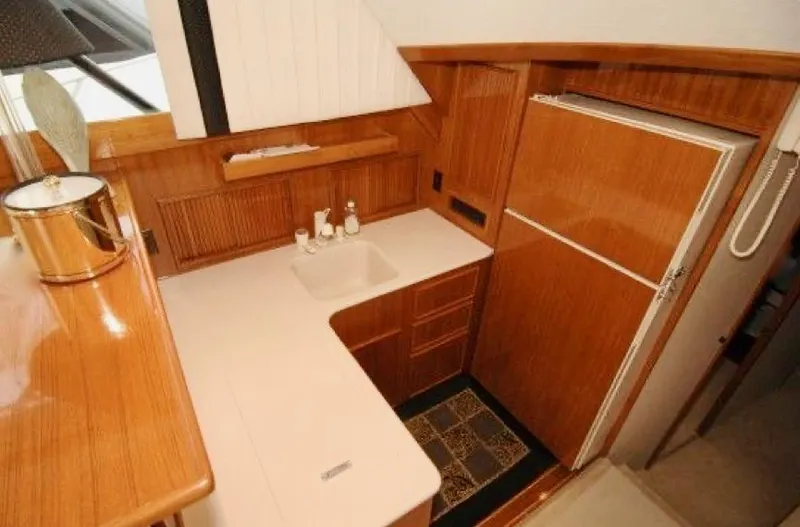 Murphy's Law Yacht Photos Pics 1997 Post 50 Convertible yacht kitchen with wooden cabinetry and modern appliances.