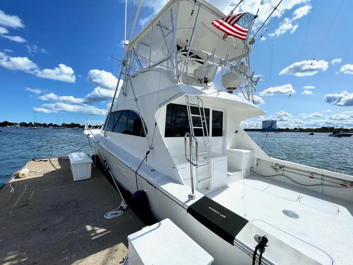 Murphy's Law Yacht Photos Pics 1997 Post 50 Convertible yacht docked by the water under a clear blue sky.