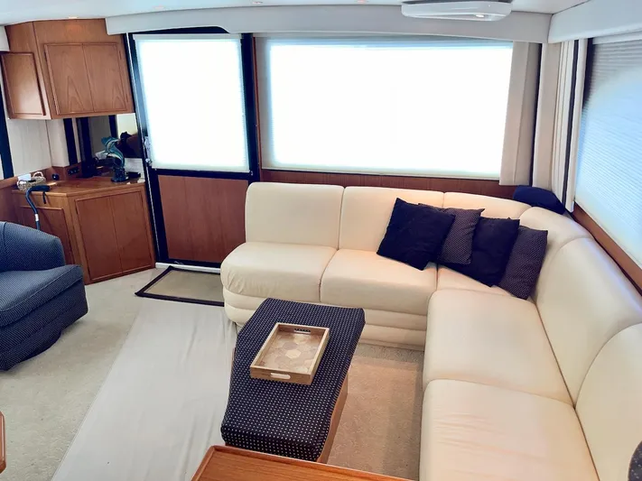 Murphy's Law Yacht Photos Pics Luxurious interior of a 1997 Post 50 Convertible yacht with cream sofa and navy accents.