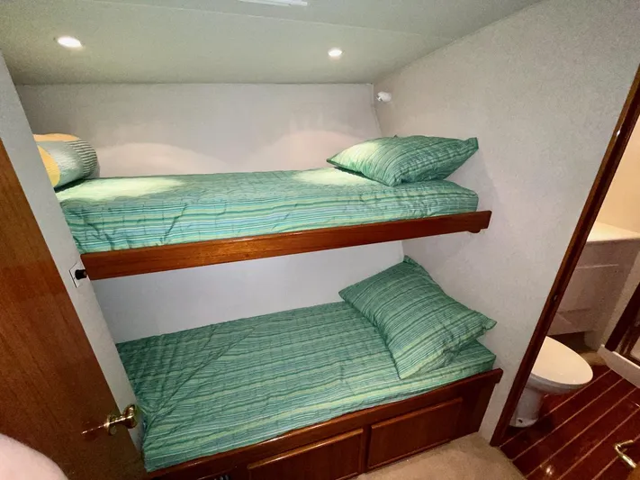 Murphy's Law Yacht Photos Pics Bunk beds with green striped bedding in a 1997 Post 50 Convertible yacht cabin.
