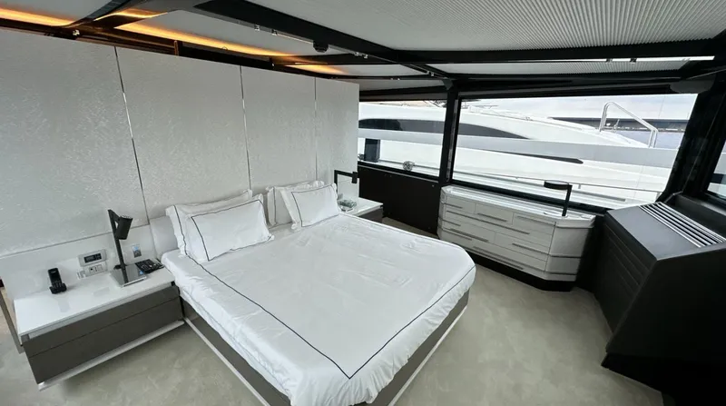  Yacht Photos Pics Luxurious bedroom on a 2017 Arcadia Yachts 100 with modern furnishings and large windows.