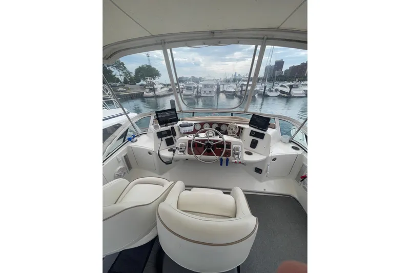  Yacht Photos Pics 2006 Silverton 35 Motor Yacht helm with marina view, featuring dual seats and navigation equipment.