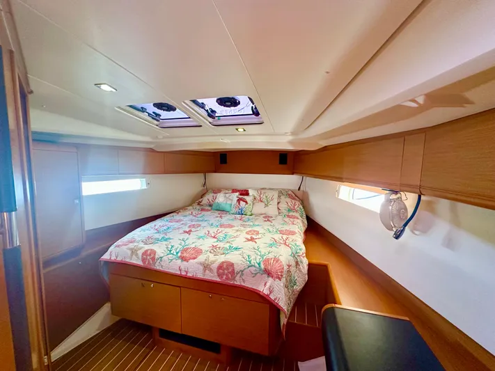 Serendipity Yacht Photos Pics Cabin interior of 2014 Jeanneau Sun Odyssey 469 with cozy bed and wooden accents.