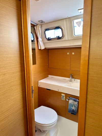 Serendipity Yacht Photos Pics Bathroom interior of 2014 Jeanneau Sun Odyssey 469 yacht, featuring wooden finish and modern fixtures.