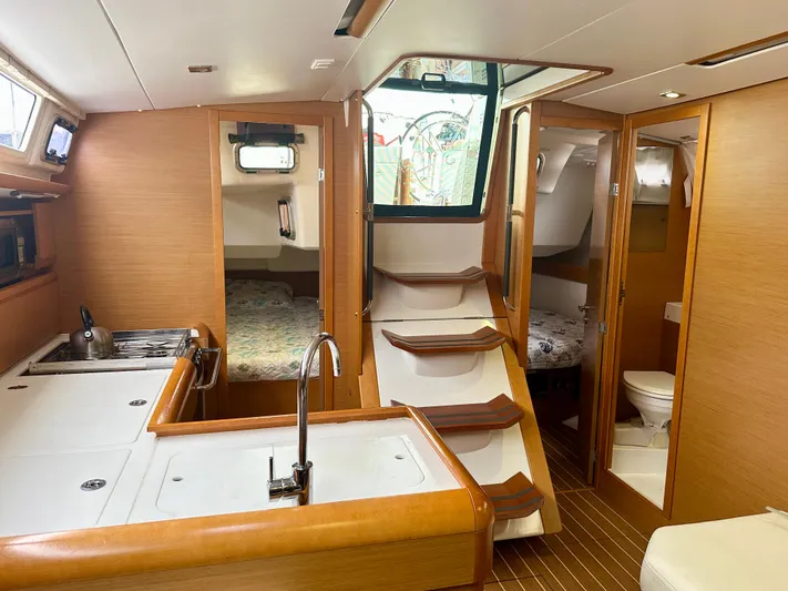 Serendipity Yacht Photos Pics Interior of 2014 Jeanneau Sun Odyssey 469 yacht, featuring kitchen, stairs, and cozy cabins.