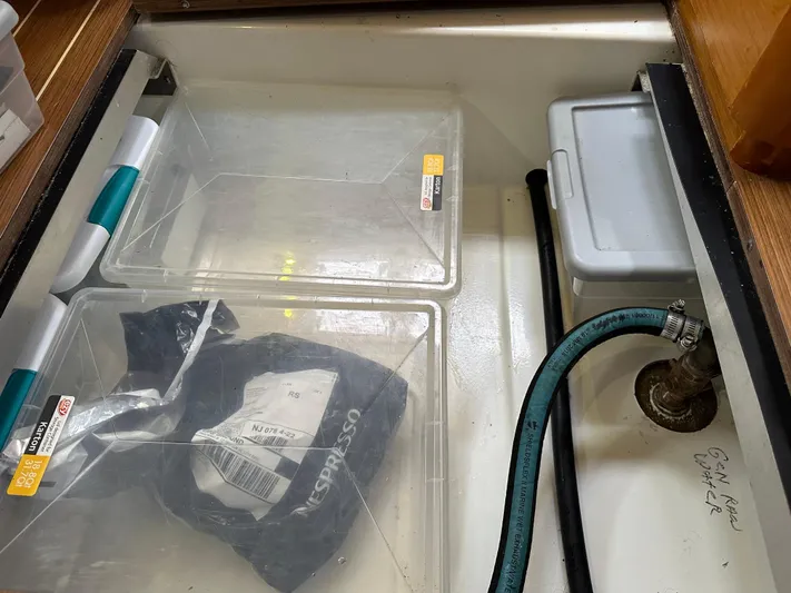 Serendipity Yacht Photos Pics Storage compartment on a 2014 Jeanneau Sun Odyssey 469 yacht with containers and hose.