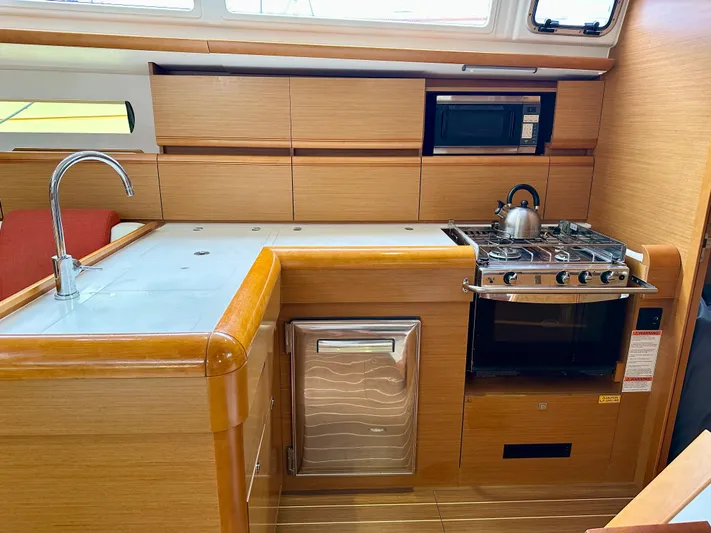 Serendipity Yacht Photos Pics Interior of 2014 Jeanneau Sun Odyssey 469 yacht kitchen with stove, sink, and microwave.