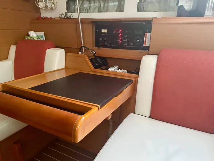 Serendipity Yacht Photos Pics Interior of 2014 Jeanneau Sun Odyssey 469 yacht with wooden table and red-white seating.