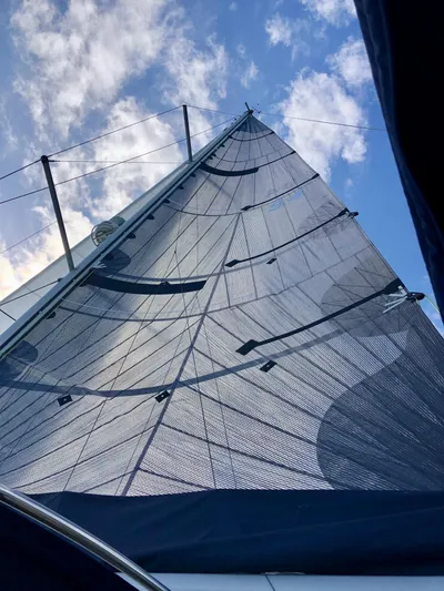 Serendipity Yacht Photos Pics Sail of 2014 Jeanneau Sun Odyssey 469 against a blue sky with clouds.
