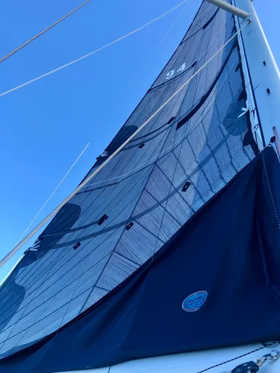 Serendipity Yacht Photos Pics 2014 Jeanneau Sun Odyssey 469 sailboat with tall sail against clear blue sky.