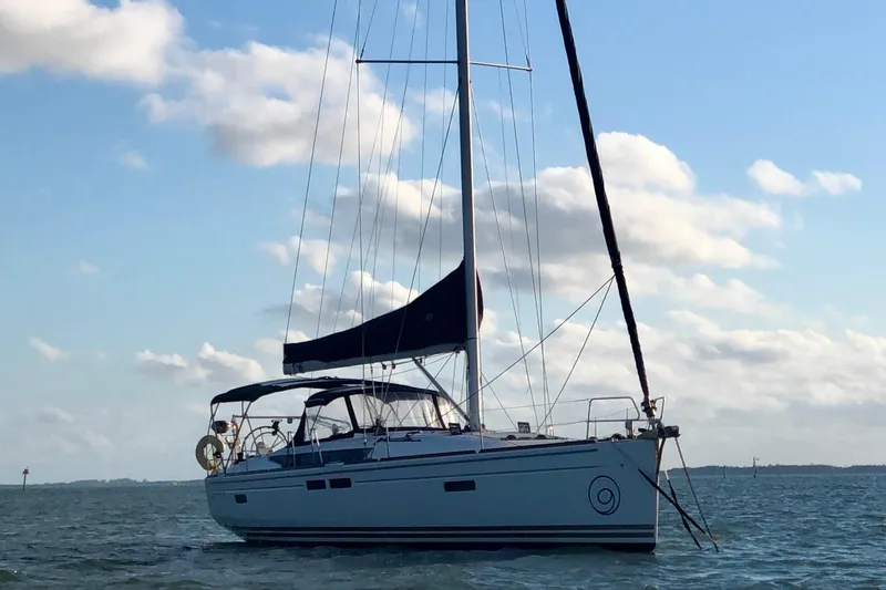 Serendipity Yacht Photos Pics 2014 Jeanneau Sun Odyssey 469 sailboat on calm water under a blue sky.