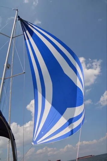 Serendipity Yacht Photos Pics Blue and white sail on 2014 Jeanneau Sun Odyssey 469 against a clear sky.