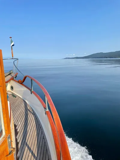 Badger Yacht Photos Pics 1980 Grand Banks 36 Classic cruising on calm waters with scenic coastal view.