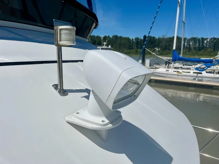  Yacht Photos Pics Close-up of a 2001 Carver 404 boat spotlight and navigation light at a marina.